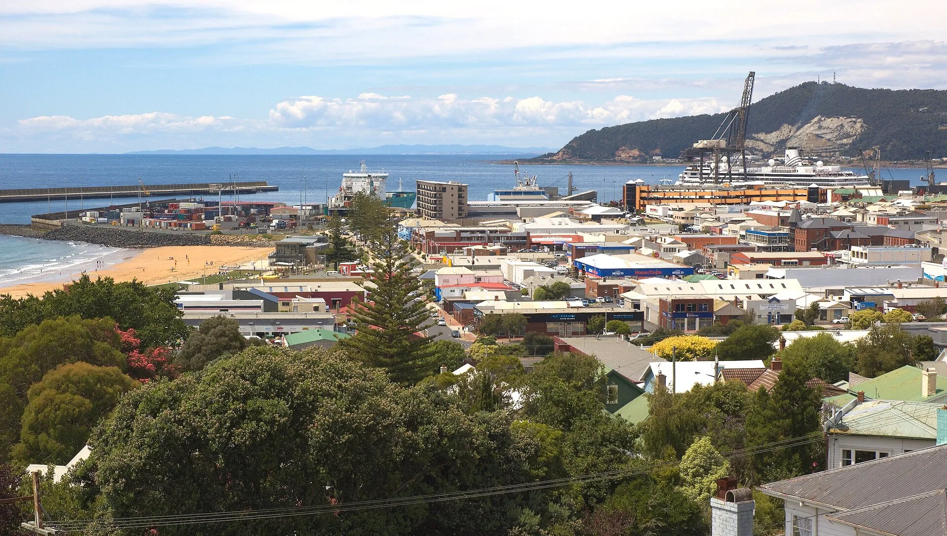 Burnie city centre, beach, and Round Hill, with cruise ship Volendam in port. The other ship on the left is Victorian Reliance.